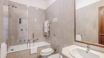 Un baño moderno con bañera, ducha, inodoro y lavamanos.