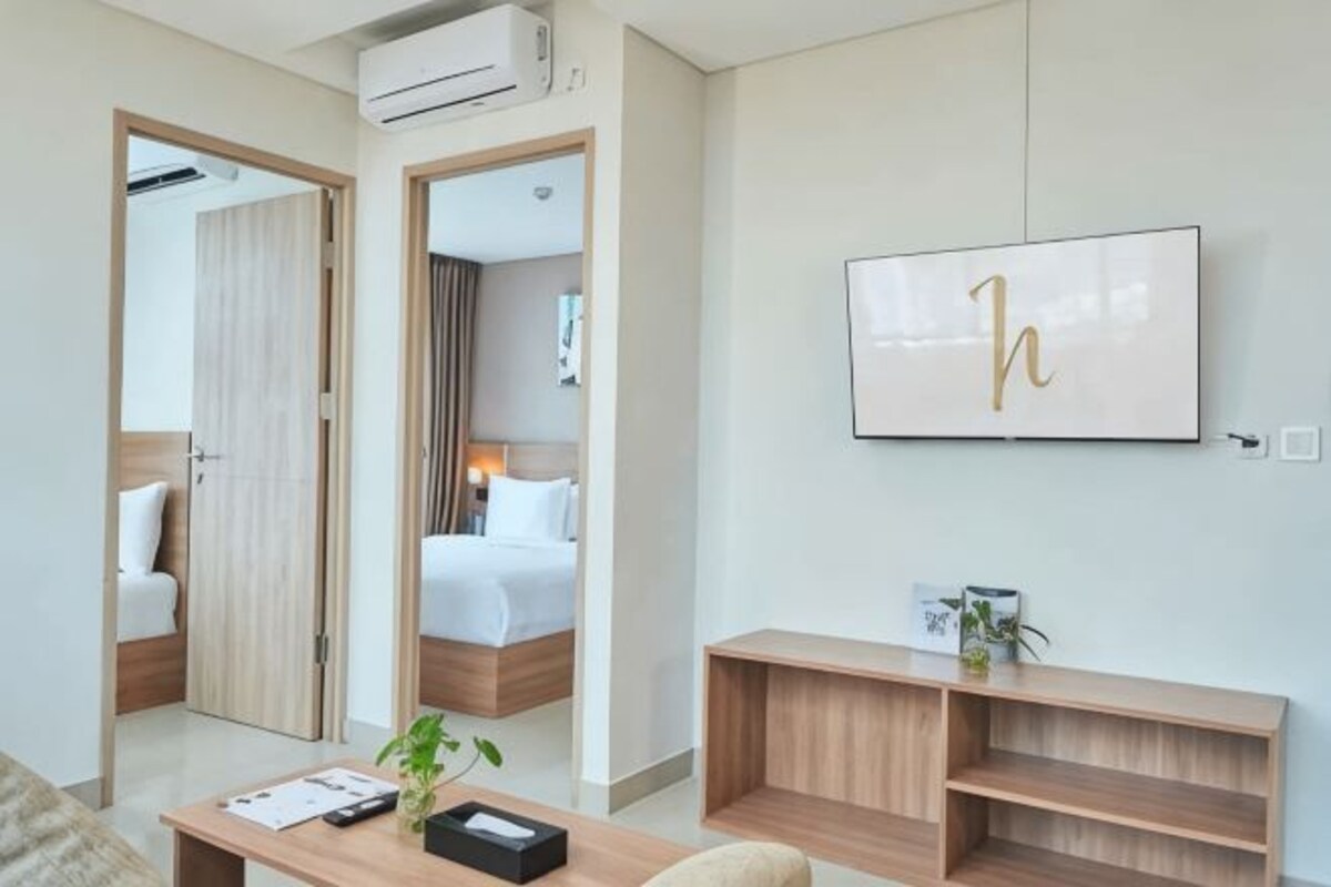 Une chambre d’hôtel avec un lit, un bureau, une télévision et un miroir.