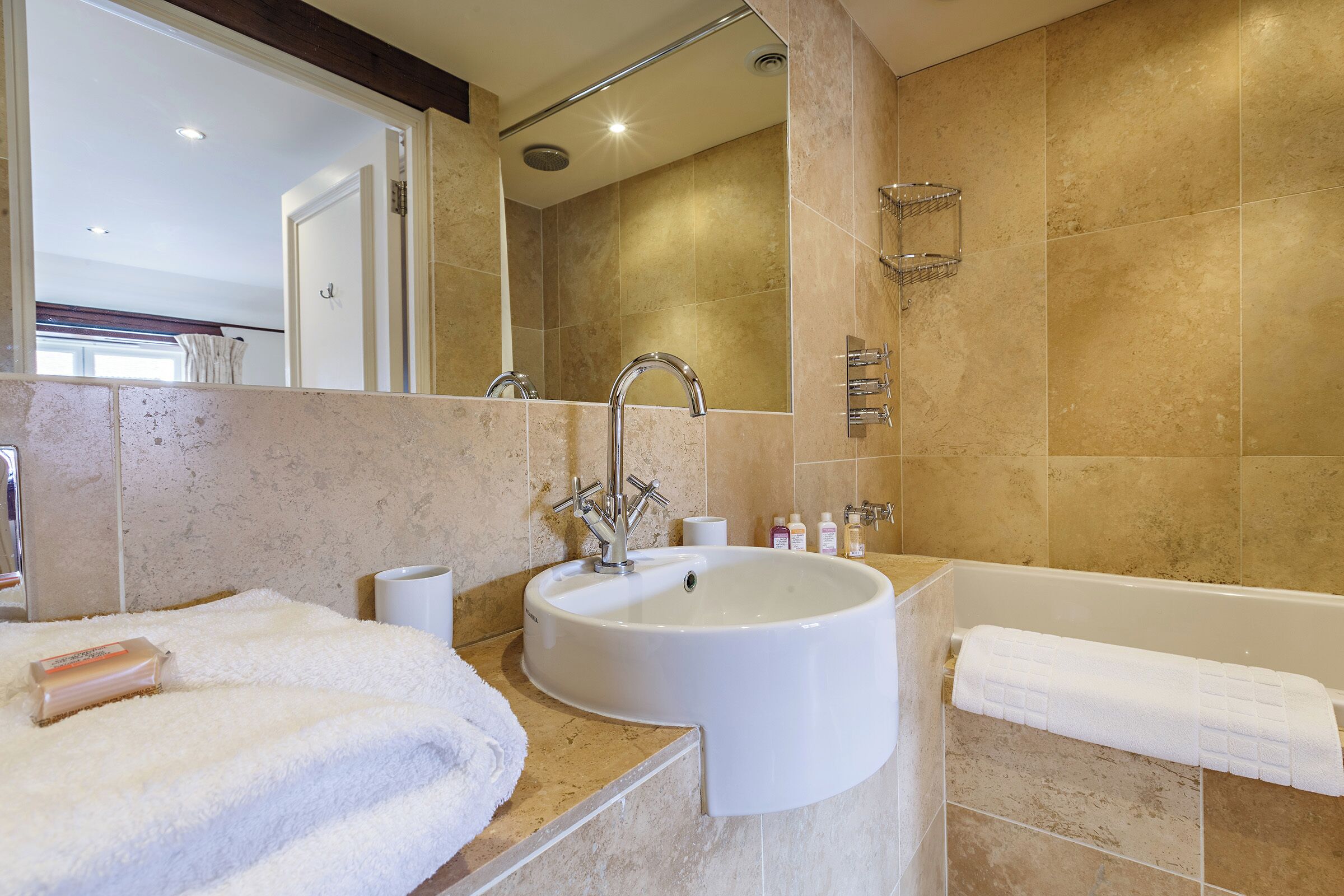 Ein Badezimmer mit Waschbecken, Spiegel und Badewanne.