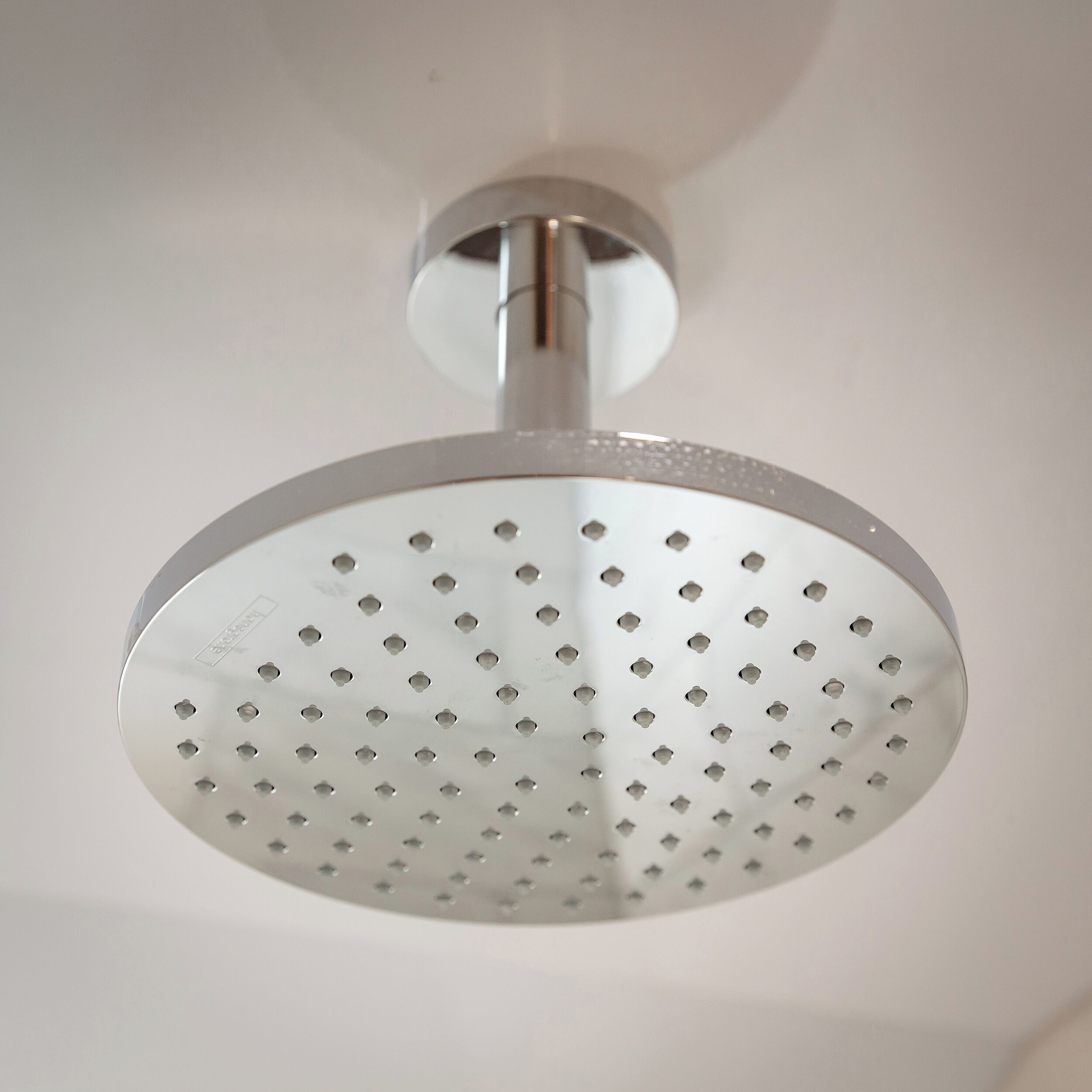 Un cabezal de ducha con un diseño circular y perforado.