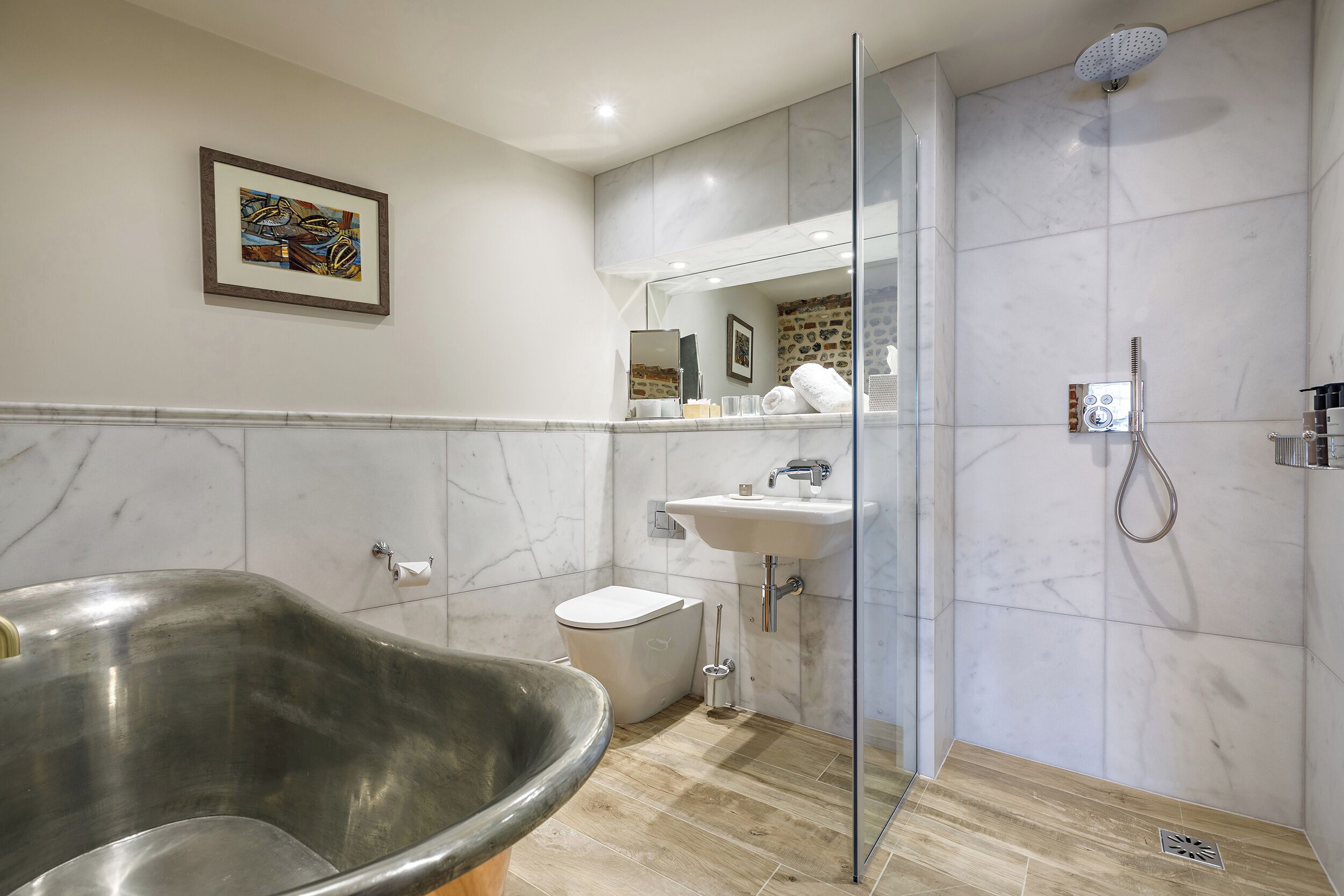 A modern bathroom with a freestanding bathtub, a toilet, a sink, and a shower.
