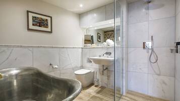A modern bathroom with a freestanding bathtub, a toilet, a sink, and a shower.
