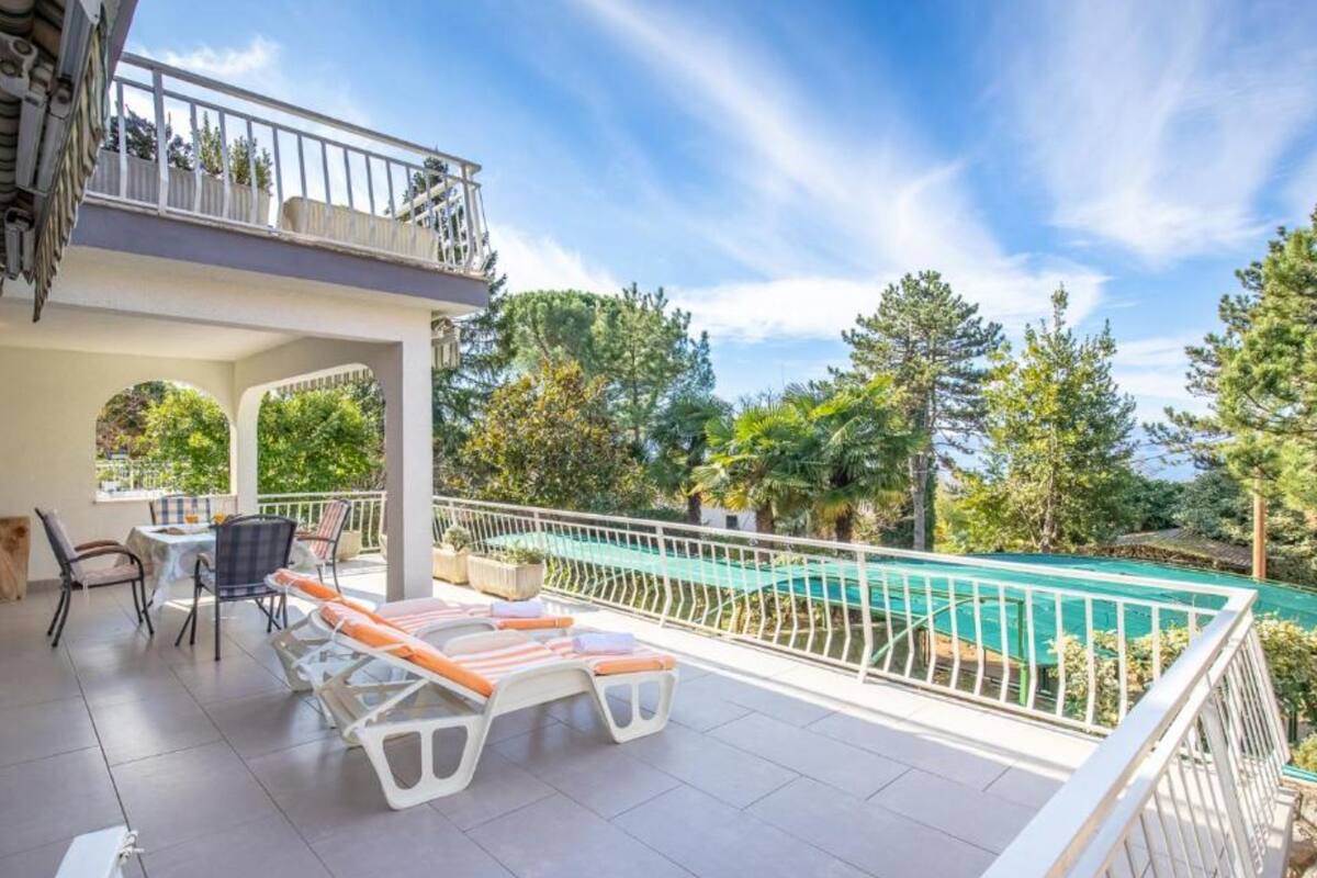 Un espace extérieur abrité comprenant une piscine, des chaises longues et une table à manger.