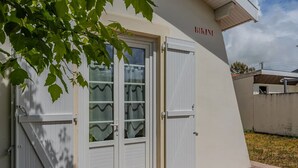 A building with a white exterior, a glass door with a wavy pattern, and a sign that reads "BIKINI".