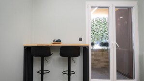 Une petite pièce avec une table en bois et deux tabourets de bar noirs.