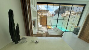 Ein Essbereich mit Tisch, Stühlen und Blick auf einen Swimmingpool und Sitzgelegenheiten im Freien.