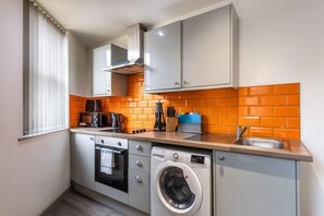 Self-catering kitchen with oven, microwave, and washing machine.