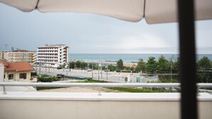 A view from a balcony overlooking a coastal area with buildings, a road, and a body of water. - Cucci House Lido Riccio (Ortona)