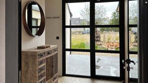 Ein modernes Badezimmer mit einem Holzlagerfläschchen, einem Spiegel und einem großen Fenster mit Blick ins Freie.