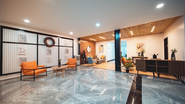 Eine moderne Lobby mit einem polierten Marmorboden, Sitzbereichen und einem Empfangstresen.