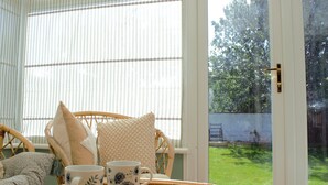 A wicker chair with cushions, a woven table, and two floral mugs on a table. - Family Seaside Bungalow - Max 6 Adults Only - 2 Small -Medium Sized Dogs Welcome - Nr Beach (Margate)
