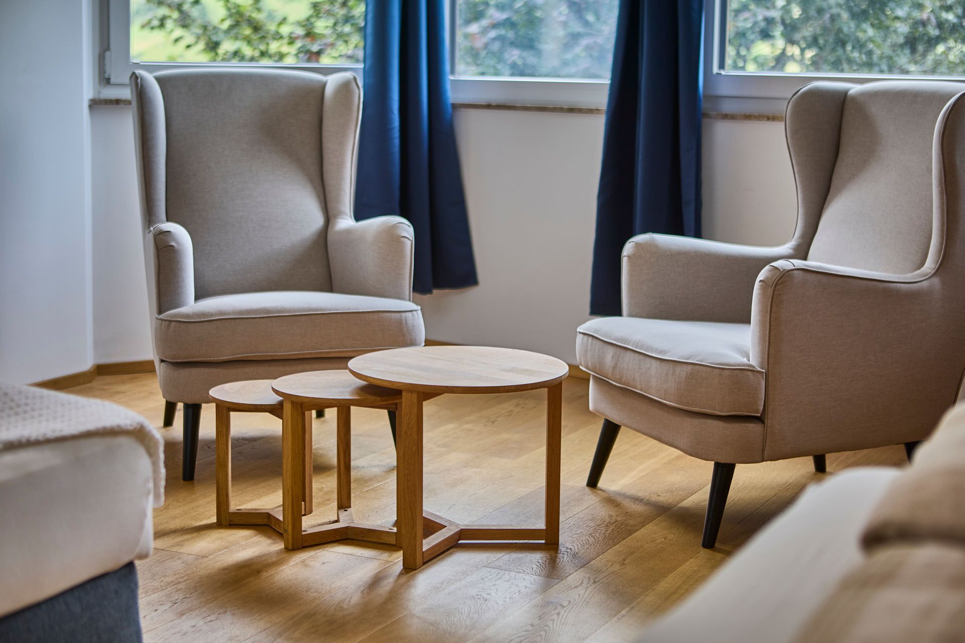 Una stanza con due poltrone beige e un tavolino in legno.