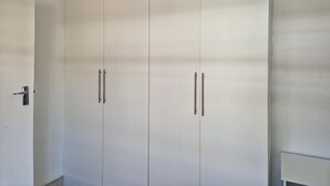 Een witte kast met twee deuren en twee handgrepen.