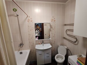 Une salle de bain avec une baignoire, un lavabo, des toilettes et un miroir.