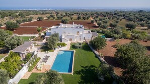 A large white villa with a swimming pool, surrounded by olive groves and a view of the sea. - Masseria Pepenofio (Monopoli)