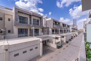 A modern residential building with multiple balconies, large windows, and a clean, contemporary design.