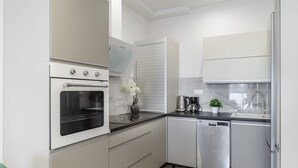 A modern kitchen with a built-in oven, dishwasher, and a coffee maker. - Lumina apart near Cinema Museum (Lódz)