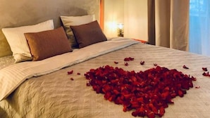 Een hotelkamer met een groot bed, een decoratieve wand en een raam met gordijnen.