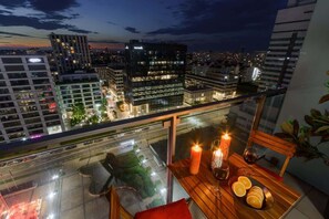 Een balkon met een tafel, kaarsen en schijfjes sinaasappel.