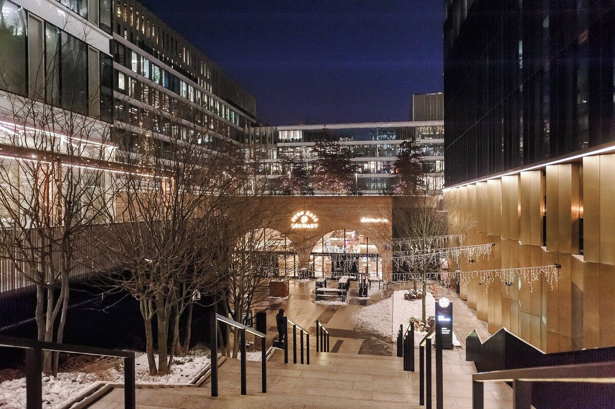 Un immeuble à plusieurs étages doté d’un atrium central, de rampes en verre et d’un sol recouvert de neige.