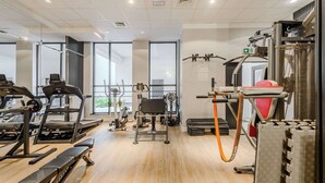 A gym with treadmills, weight machines, and a pull-up bar. - Lumina cozy apartment with gym in the City Center (Warszawa)