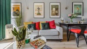 A living room with a sofa, a coffee table, and framed artwork on the wall. - Lumina lux apartment in Warsaw (Warszawa BIG)