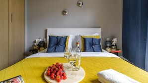 A hotel room with a bed, a bedside table, a magazine, a tray with strawberries and wine glasses, and a towel. - Lumina lux apartment in Warsaw (Warszawa BIG)