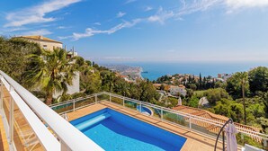 Une piscine avec vue sur la mer et les bâtiments environnants.
