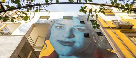 Un mural en la fachada de un edificio con un diseño geométrico y balcones.