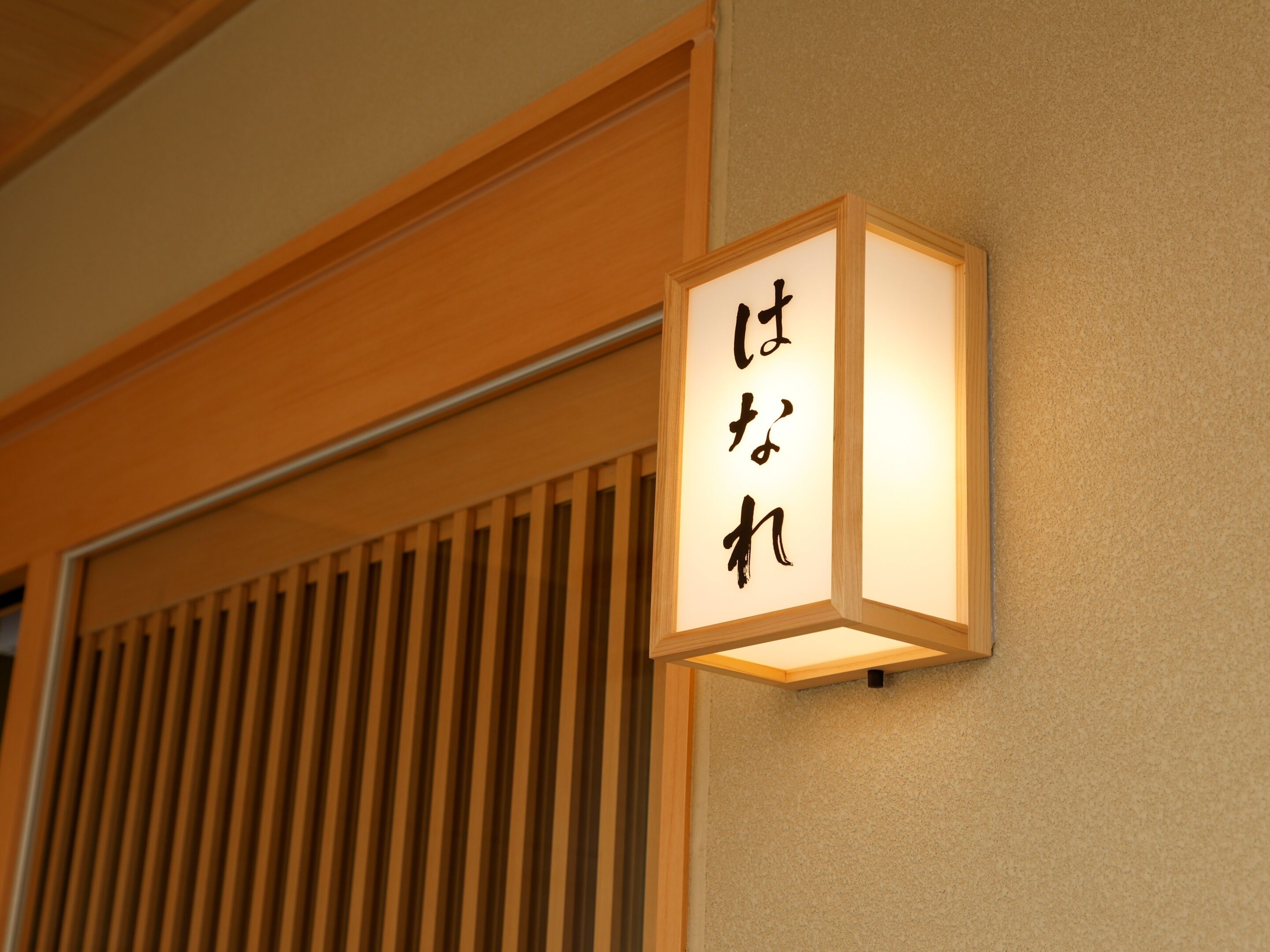 Eine traditionelle japanische Laterne mit Kalligraphie an einer Wand.