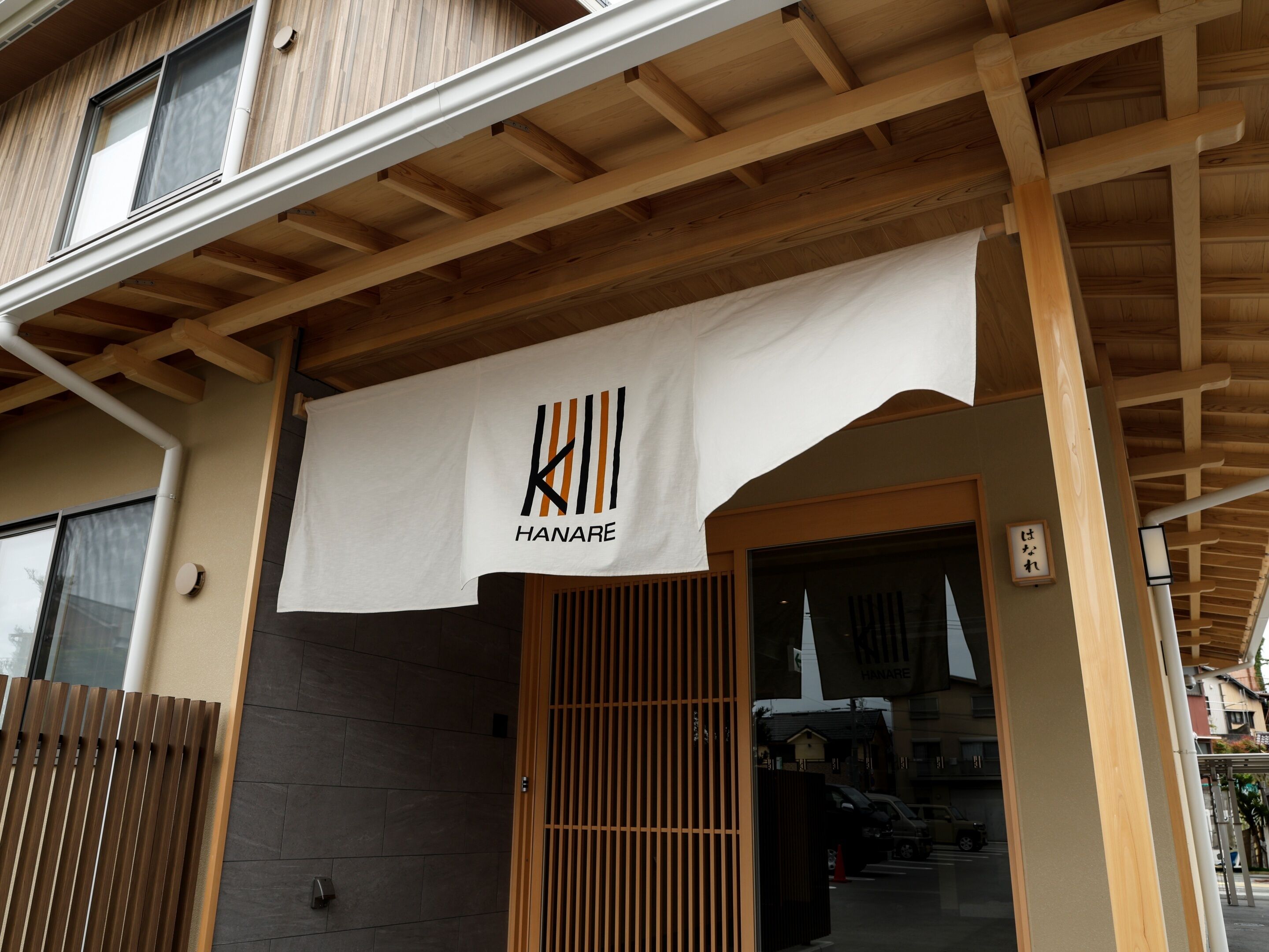 A building entrance with a wooden facade and a sign that reads 'KILL HANARE'.