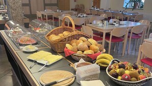 A buffet setup with various food items and a knife on a cutting board. - Gästehäuser St Marienthal (Ostritz)