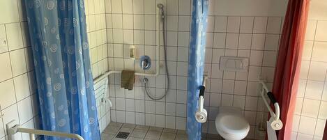 Un baño con ducha, inodoro y lavamanos.