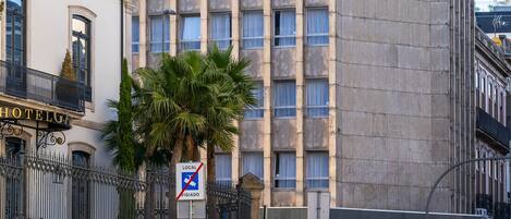 A hotel with a modern facade, multiple windows, and a sign indicating no parking.