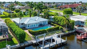 Uma casa com piscina, píer e vegetação exuberante.