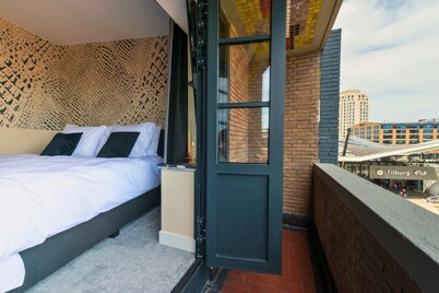 Experience the unique De Stijl–inspired design of Nelly van Doesburg in this affordable, stylish suite in central Tilburg. A smart choice for travelers who value fast Wi-Fi, comfort, and a prime city location.