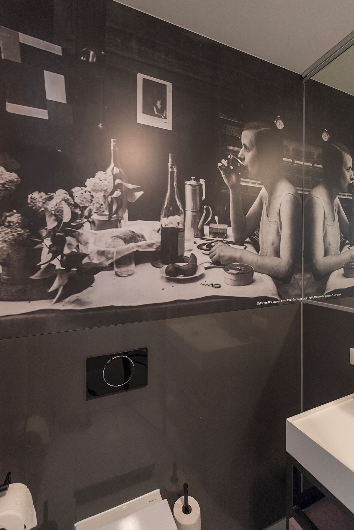 Een badkamer met een spiegel, een wastafel en een zeepdispenser.