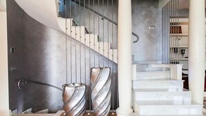 A modern staircase with a metal railing and a marble floor. - Perched above the gleaming waters of Lake Como (Riva)