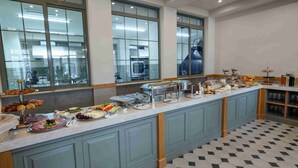 A buffet setup with various food items and a kitchen in the background. - Grand Hotel Gyumri  (Gyumri)