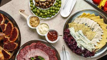 A variety of food items including meats, cheeses, olives, and vegetables arranged on a table.