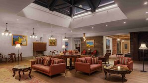 A spacious living room with leather sofas, a round coffee table, and a fireplace. - Grand Hotel Gyumri  (Gyumri)