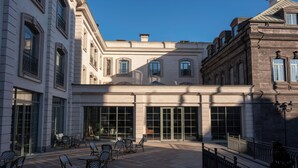 A courtyard with outdoor seating and large windows. - Grand Hotel Gyumri  (Gyumri)