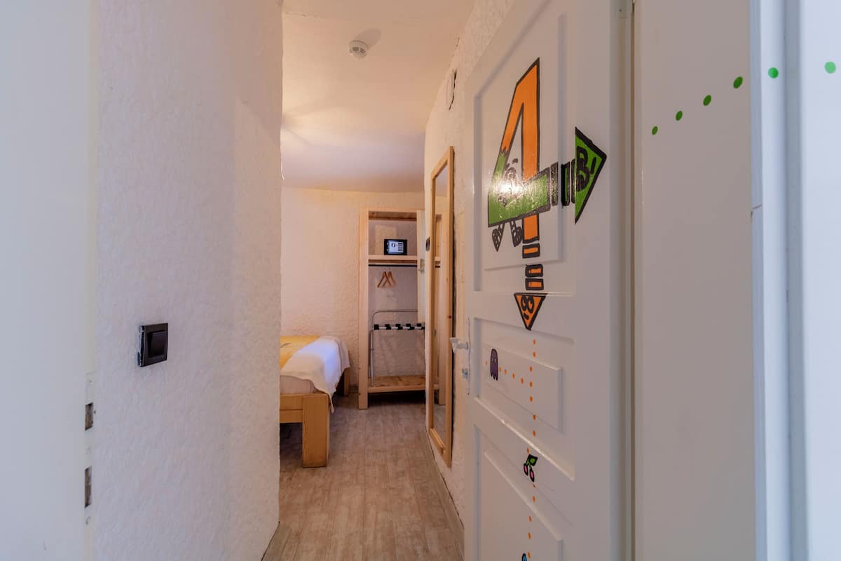 A narrow hallway with a bed and a door with a number 4 sign.