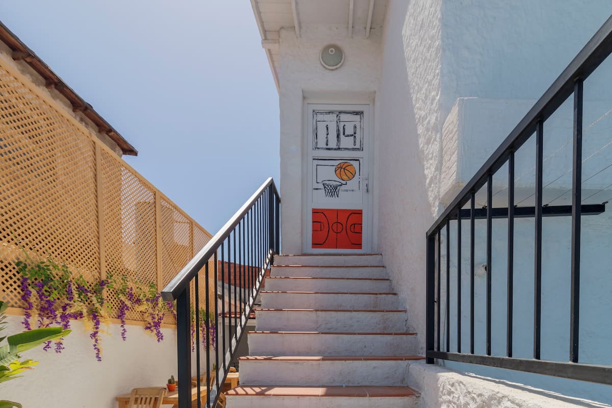 A staircase with a white door, a basketball hoop, and a door number.