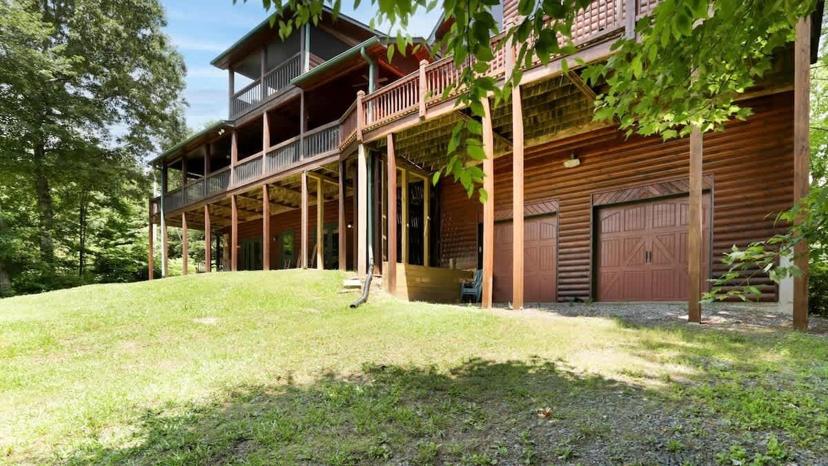 A wooden cabin with a covered porch and a garage.