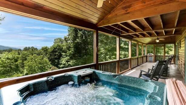 A hot tub on a wooden deck with a view of a forested landscape. - Scenic Mountain Cabin w/ Hot Tub & Fire Pit (Blue Ridge)
