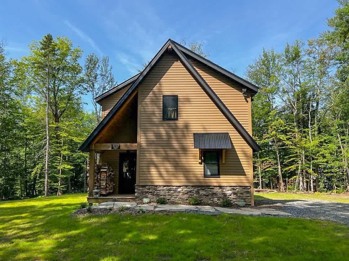 A lodge with a stone foundation, a wooden exterior, and a pitched roof.