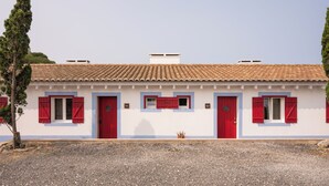 A building with a white facade, red shutters, and a tiled roof. - Nômade Melides Eco Lodge (Grandola)