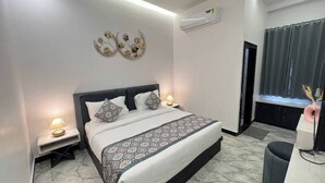 Ein modernes Schlafzimmer mit einem großen Bett, Nachttischlampen, einem Deckenventilator und einer Klimaanlage.