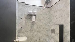 Ein Badezimmer mit Marmorboden, einem weißen Waschbecken, einer Toilette und einem Handtuchhalter.